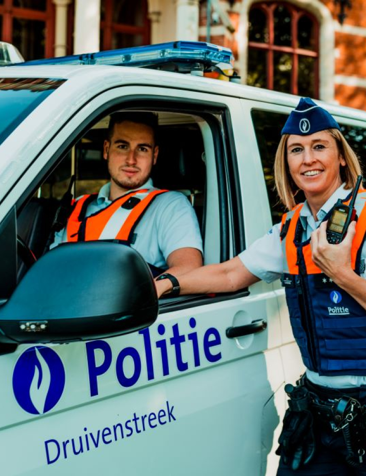 politieman en politievrouw naast combi