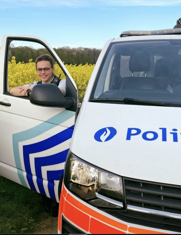 Politievrouw aan dienstvoertuig