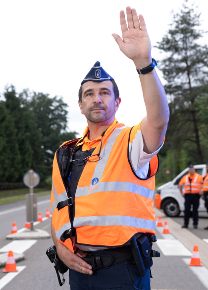 Mannelijke inspecteur van verkeer doet het verkeer stoppen